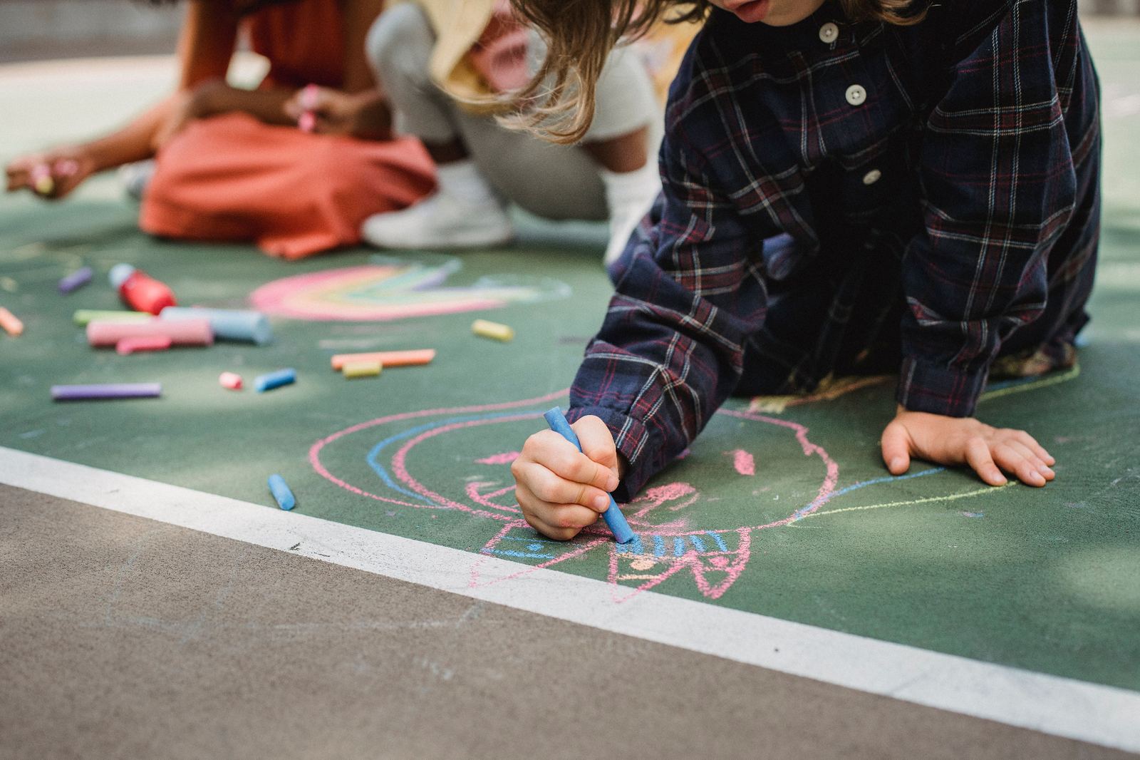 Children drawing and playing with chalk outdoors